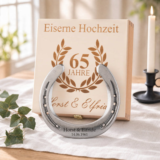 Glückshufeisen zur Eisernen Hochzeit in Natur mit Namensgravur vor der Holz-Geschenkbox, Deckel graviert mit Lorbeerkranz, 65 Jahre und Namen