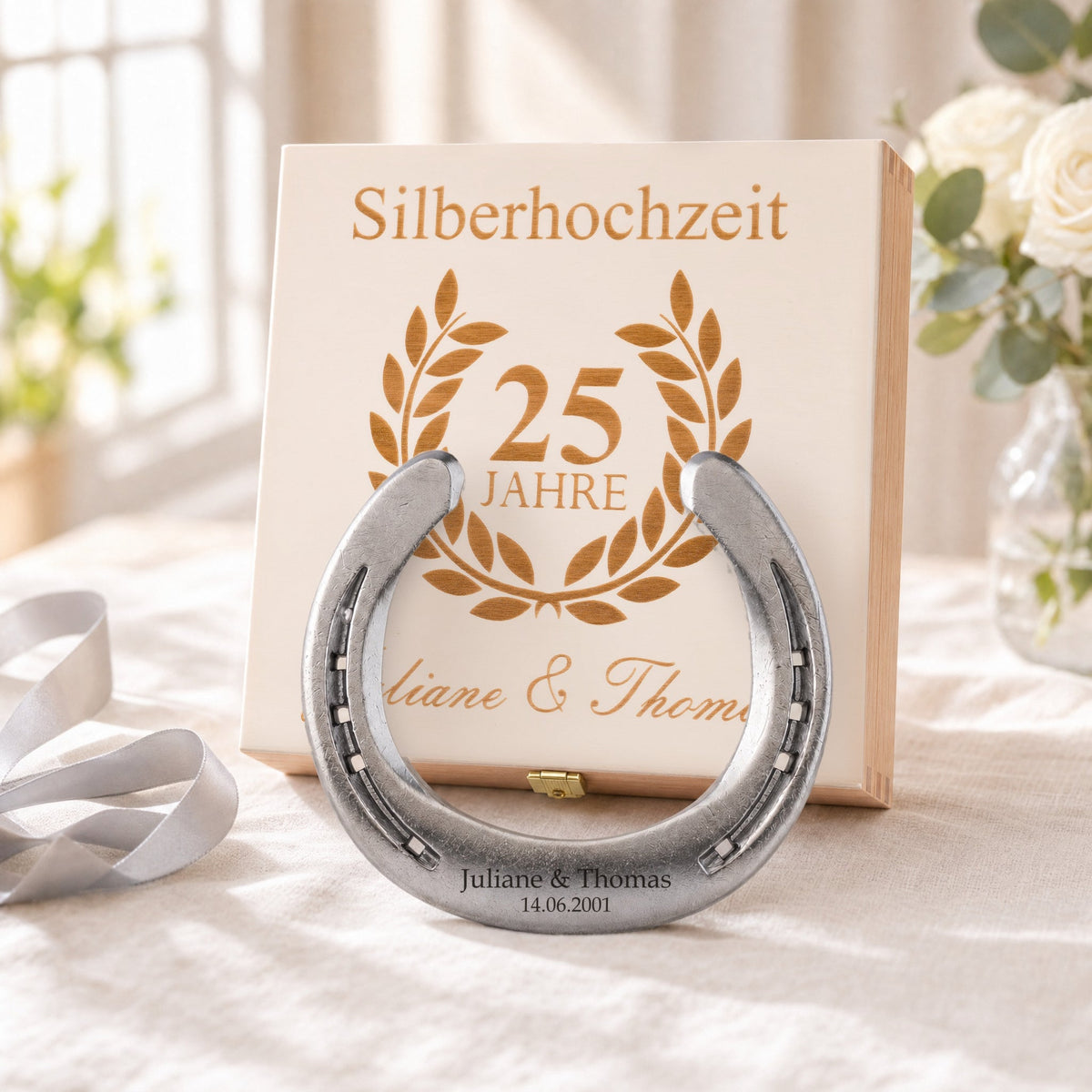 Glückshufeisen zur Silberhochzeit in Natur mit Namensgravur vor der Holz-Geschenkbox, Deckel graviert mit Lorbeerkranz, 25 Jahre und Namen