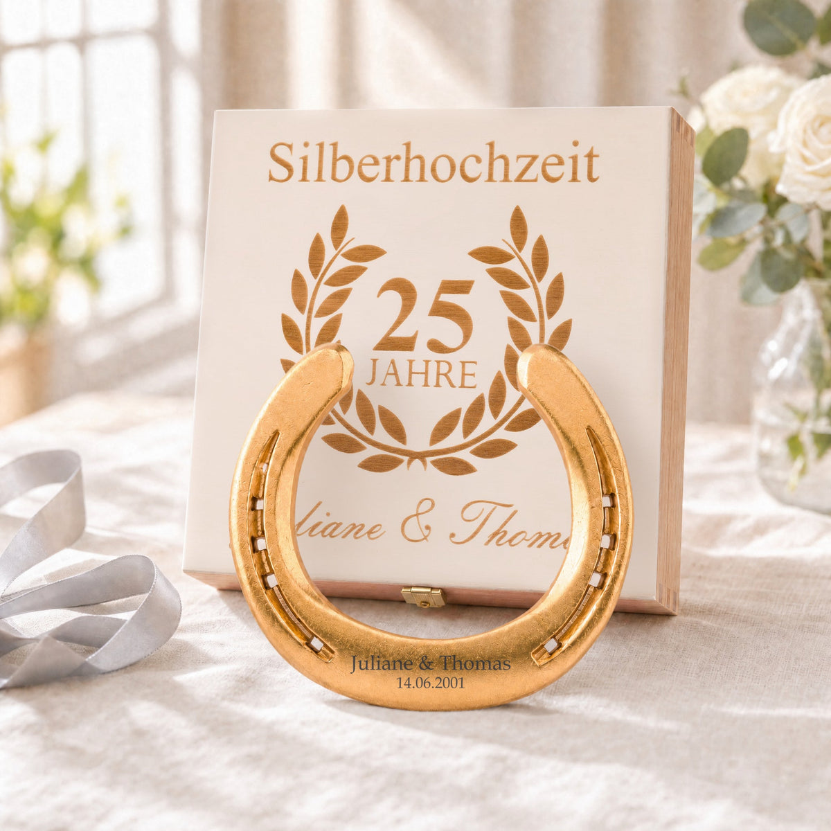 Vergoldetes Glückshufeisen (24 Karat) zur Silberhochzeit mit Namensgravur vor der Holz-Geschenkbox, Deckel graviert mit Lorbeerkranz, 25 Jahre und Namen